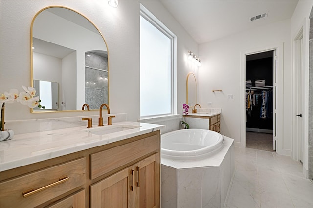 bathroom with tiled bath and vanity