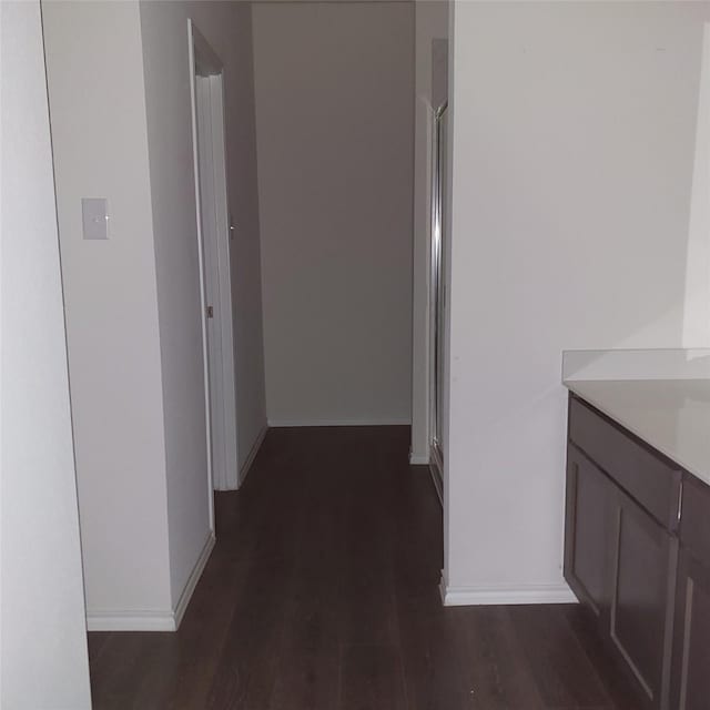 hallway with dark hardwood / wood-style flooring