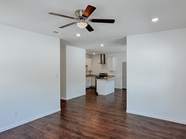 unfurnished living room featuring dark wood-type flooring and ceiling fan