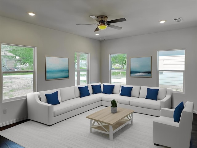 living room with a wealth of natural light, light hardwood / wood-style floors, and ceiling fan