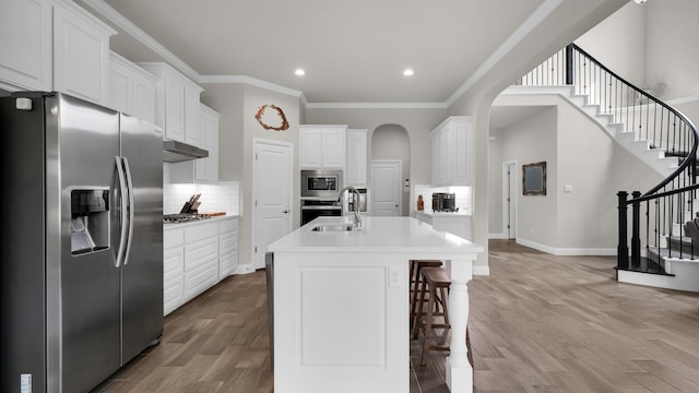 kitchen featuring white cabinets, stainless steel appliances, and a kitchen island with sink