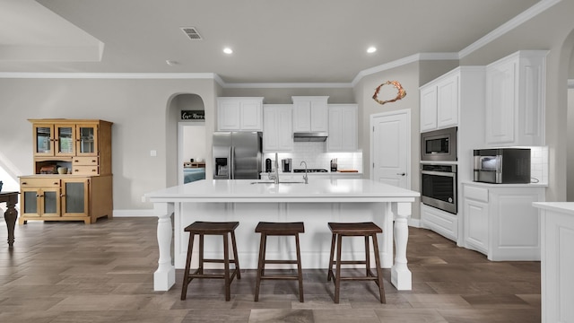 kitchen featuring sink, an island with sink, a breakfast bar area, white cabinets, and appliances with stainless steel finishes