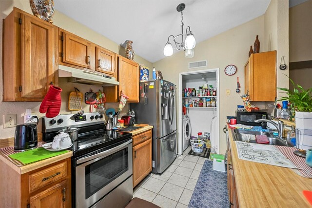 kitchen featuring pendant lighting, independent washer and dryer, light tile patterned floors, a notable chandelier, and stainless steel appliances