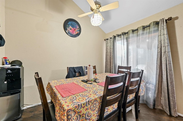 dining area with ceiling fan, dark wood-type flooring, and vaulted ceiling