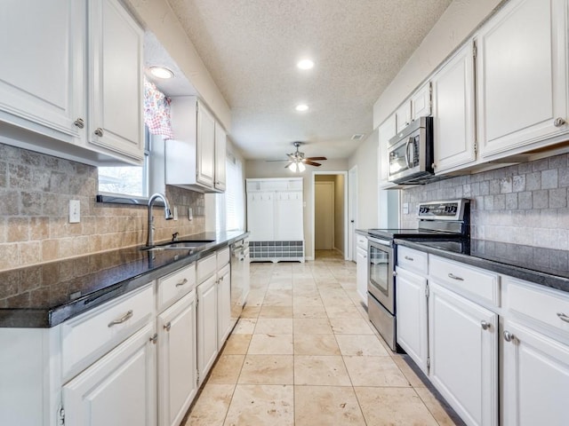 kitchen with sink, ceiling fan, a textured ceiling, appliances with stainless steel finishes, and white cabinetry