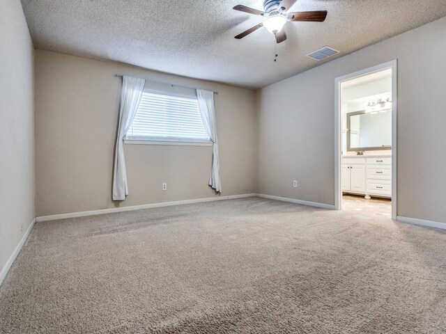 unfurnished room featuring light carpet, sink, ceiling fan, and a textured ceiling