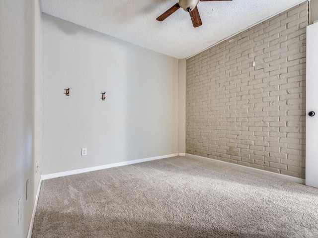 unfurnished room with carpet flooring, ceiling fan, brick wall, and a textured ceiling