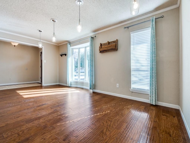 empty room with ornamental molding, wood-type flooring, and a textured ceiling