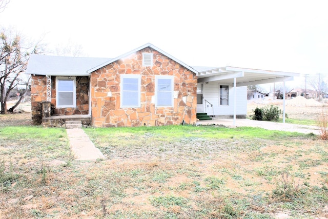 view of front of property featuring a front yard and a carport