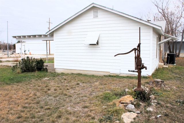 view of property exterior with a yard and cooling unit