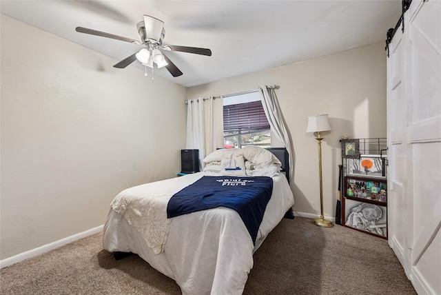 carpeted bedroom featuring a barn door and ceiling fan