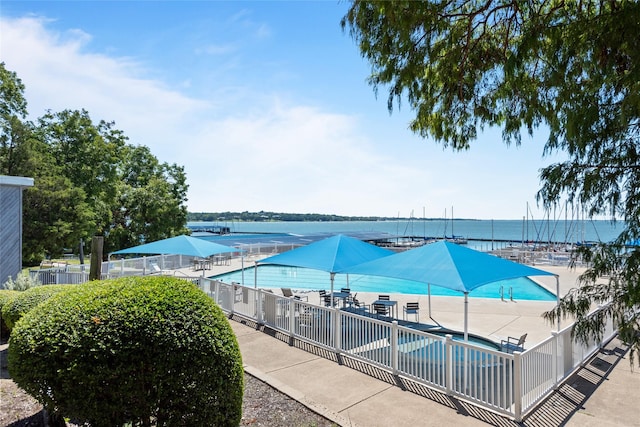 view of pool featuring a water view and a patio