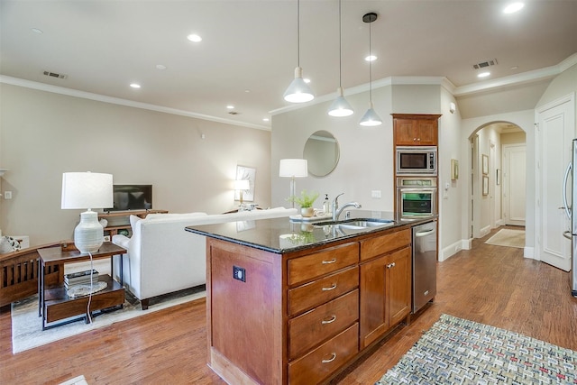 kitchen with sink, hardwood / wood-style floors, pendant lighting, a center island with sink, and appliances with stainless steel finishes