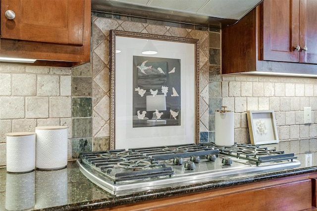 interior space with backsplash, exhaust hood, and stainless steel gas stovetop