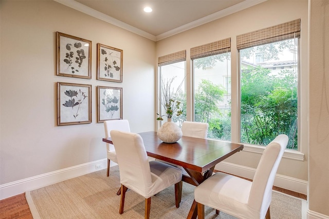 dining space with hardwood / wood-style floors and crown molding