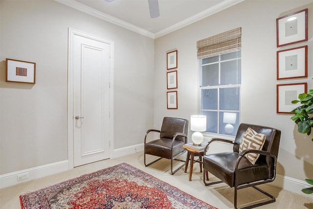 sitting room with ceiling fan, ornamental molding, and light carpet