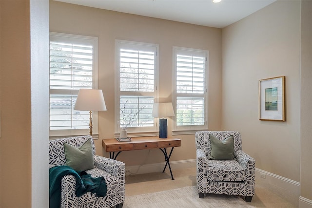 living area featuring light carpet and a healthy amount of sunlight