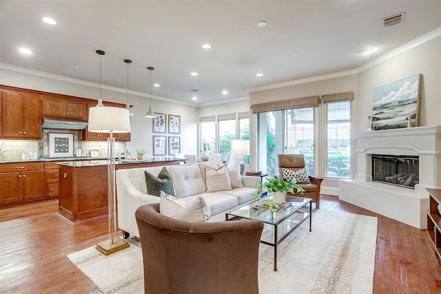 living room with light hardwood / wood-style floors and ornamental molding