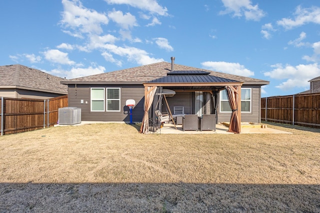 rear view of property with a gazebo, central air condition unit, and a patio