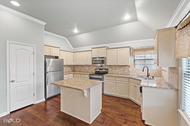 kitchen with lofted ceiling, sink, a kitchen island, light stone counters, and stainless steel appliances