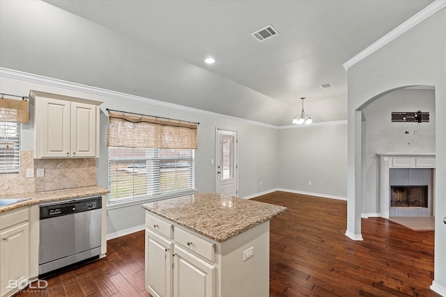 kitchen with a center island, lofted ceiling, hanging light fixtures, stainless steel dishwasher, and a fireplace