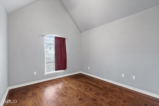 spare room featuring wood-type flooring and high vaulted ceiling