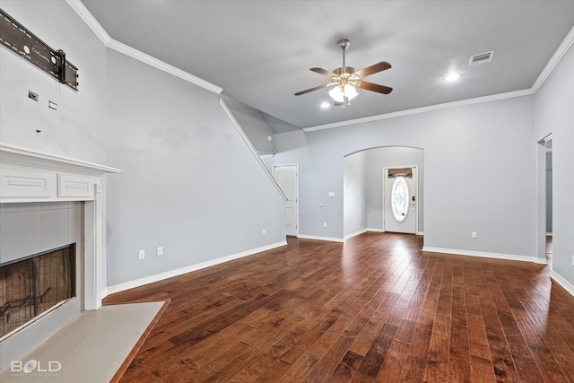 unfurnished living room featuring ceiling fan, a fireplace, crown molding, and dark wood-type flooring