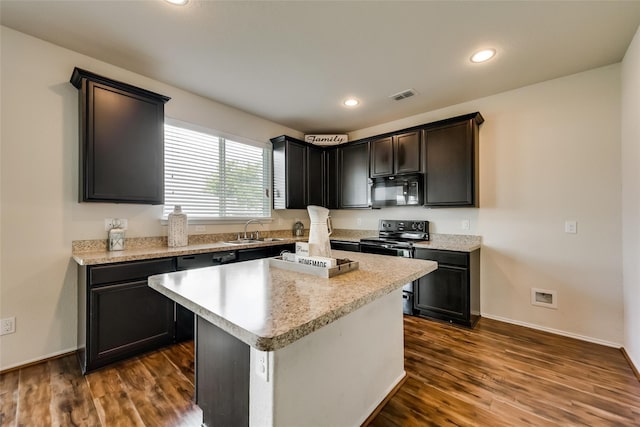 kitchen featuring sink, dark hardwood / wood-style floors, a kitchen island, and black appliances