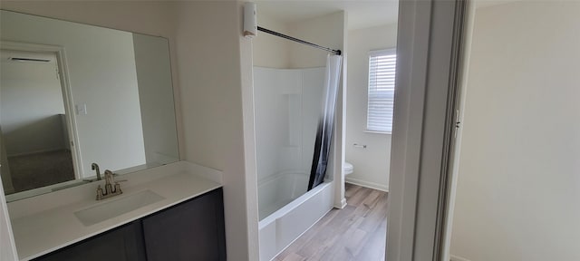 full bathroom featuring hardwood / wood-style floors, vanity, shower / tub combo, and toilet