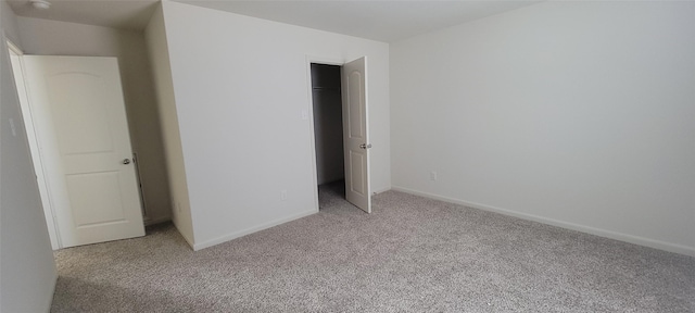 unfurnished bedroom featuring light carpet and a closet