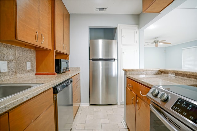 kitchen featuring appliances with stainless steel finishes, backsplash, and ceiling fan