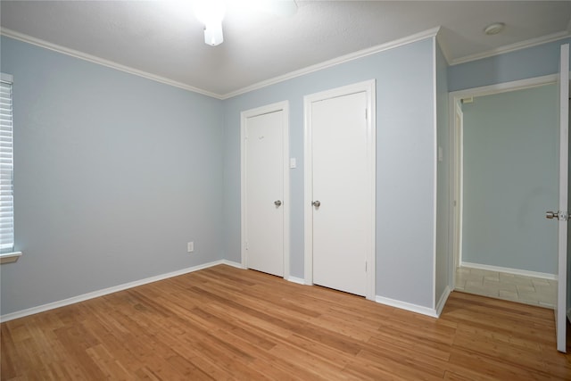 unfurnished bedroom with ornamental molding and light hardwood / wood-style flooring