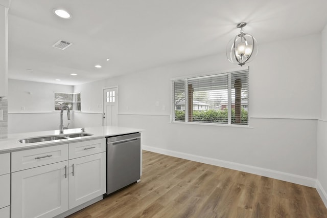 kitchen featuring dishwasher, light hardwood / wood-style floors, white cabinets, decorative light fixtures, and sink