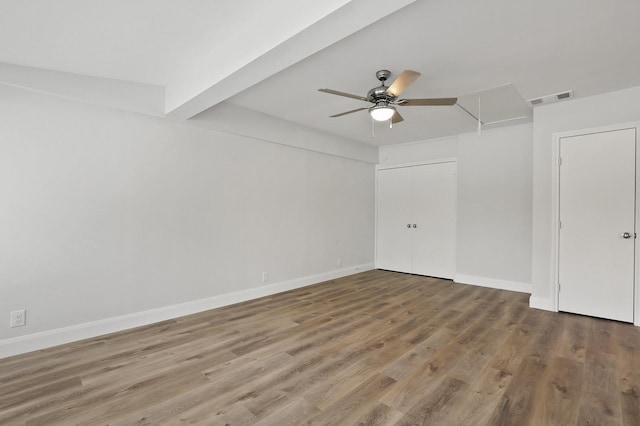 unfurnished room with hardwood / wood-style flooring, ceiling fan, and beamed ceiling