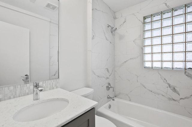 full bathroom with toilet, tiled shower / bath combo, and vanity