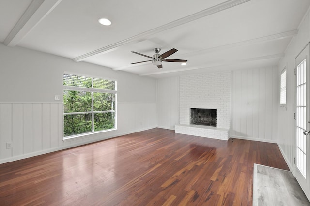 unfurnished living room with a brick fireplace, dark wood-type flooring, ceiling fan, and beamed ceiling