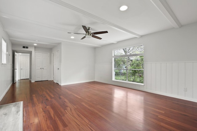 spare room featuring dark hardwood / wood-style floors, ceiling fan, and beam ceiling