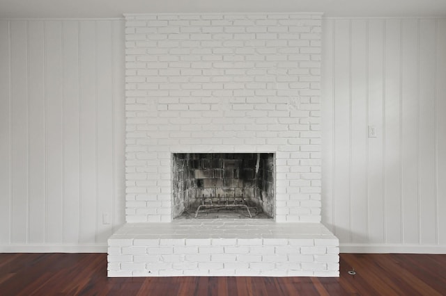 interior details with hardwood / wood-style floors and a brick fireplace