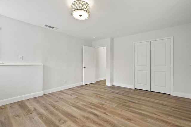 unfurnished bedroom featuring light wood-type flooring and a closet