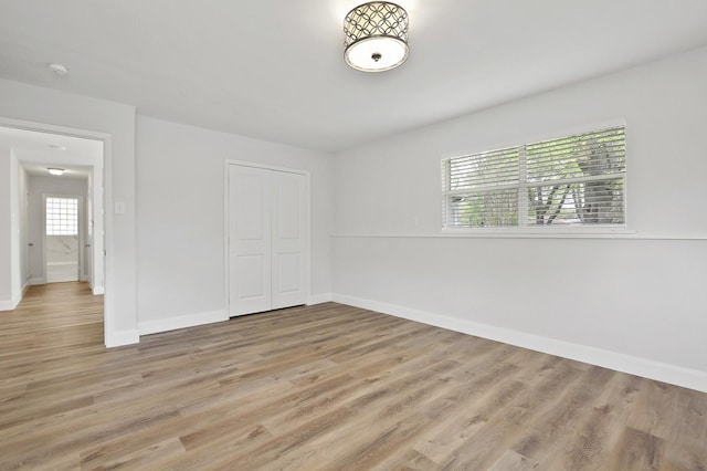 unfurnished bedroom featuring light wood-type flooring and a closet