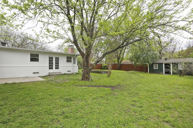 view of yard with french doors and an outbuilding