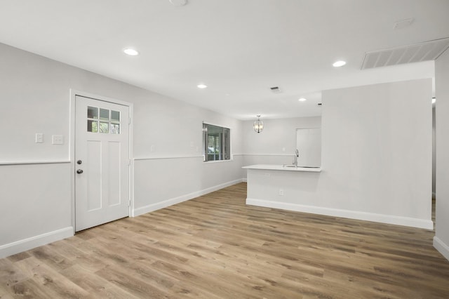 interior space featuring light hardwood / wood-style floors, a chandelier, sink, and plenty of natural light