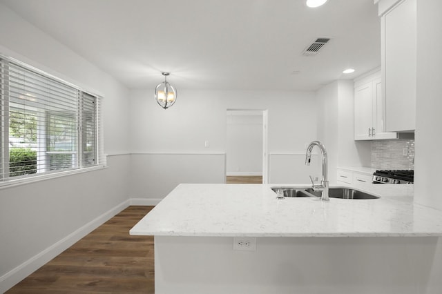 kitchen with sink, white cabinetry, kitchen peninsula, hanging light fixtures, and light stone countertops