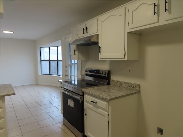 kitchen featuring white cabinets, light tile patterned flooring, and stainless steel electric range oven