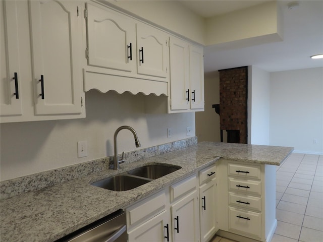 kitchen featuring white cabinetry, sink, light stone countertops, kitchen peninsula, and light tile patterned flooring