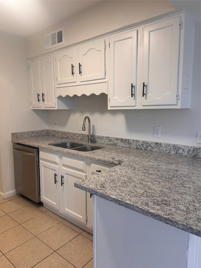 kitchen with dishwasher, white cabinets, sink, light stone countertops, and light tile patterned flooring