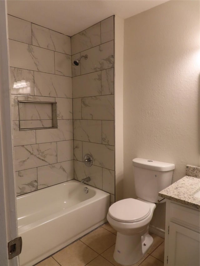 full bathroom featuring vanity, tile patterned flooring, tiled shower / bath, and toilet