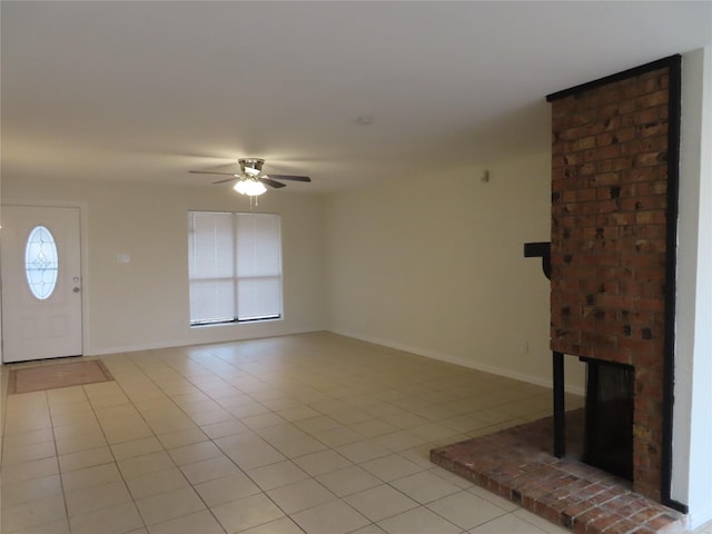 unfurnished living room featuring ceiling fan, a fireplace, and light tile patterned floors