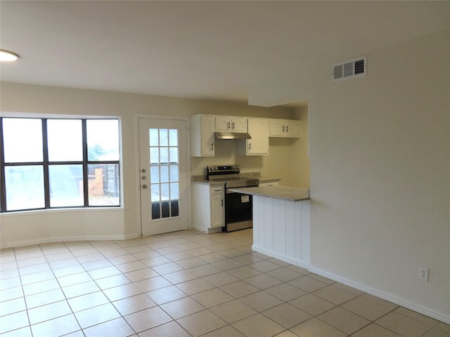 kitchen with white cabinets, light stone counters, electric stove, and light tile patterned floors