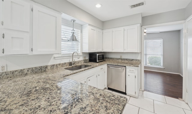 kitchen with sink, light stone counters, hanging light fixtures, stainless steel appliances, and white cabinets